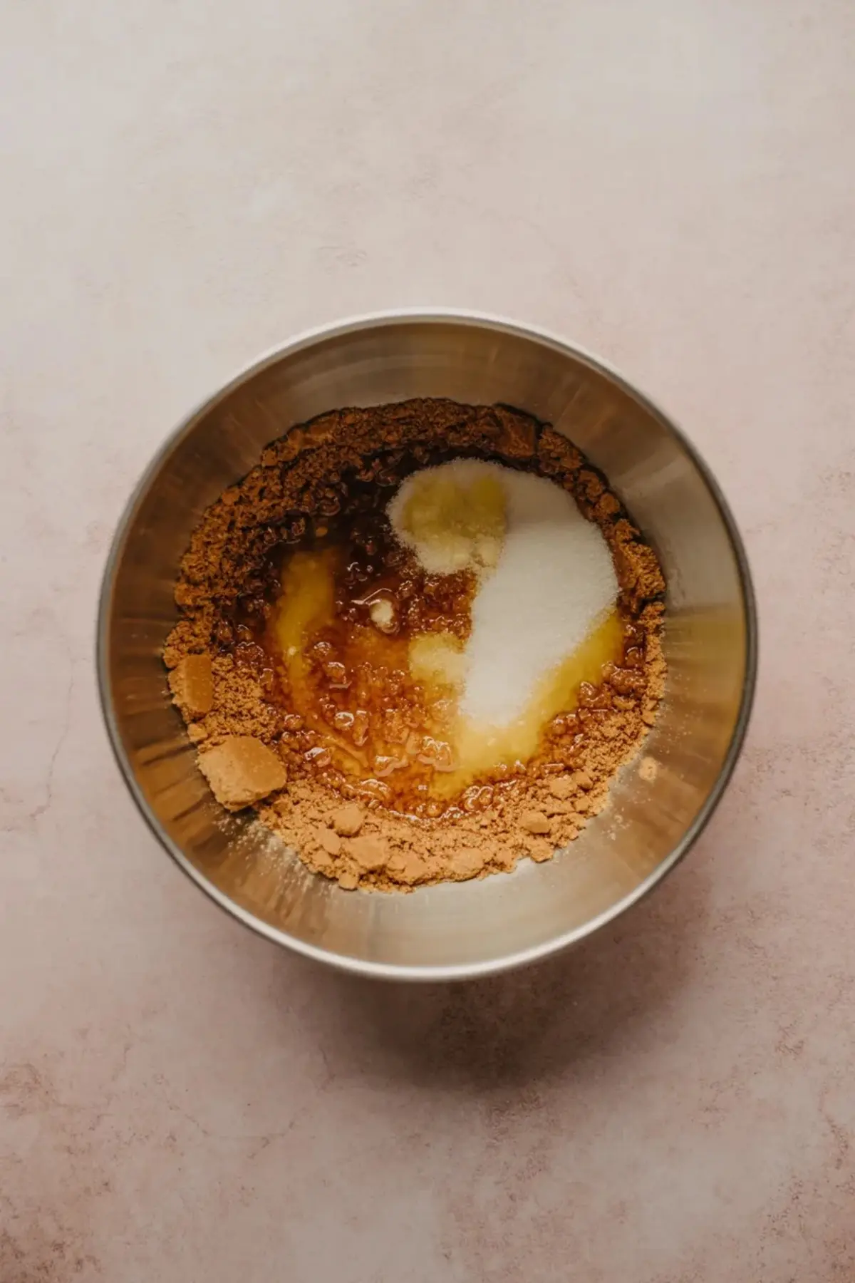A graham cracker crust is pressed into a parchment-lined square pan for coconut cream pie bars before baking.